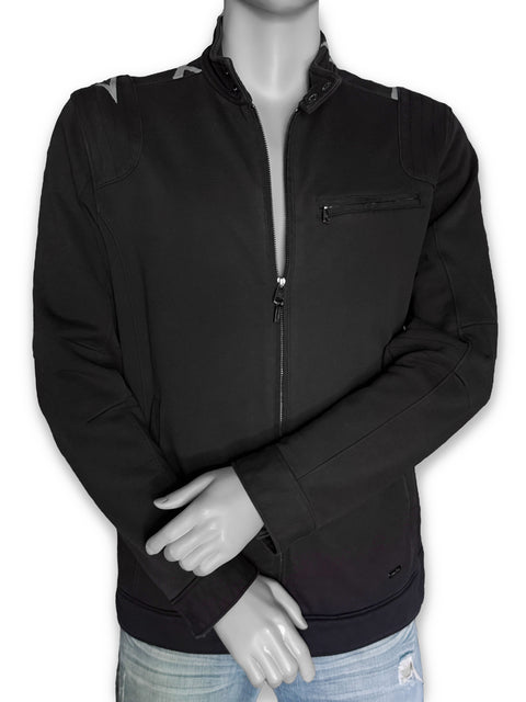 The front of a black zip-up jacket with hints of painted lines on the shoulders, displayed on a gray mannequin torso with light blue jeans.