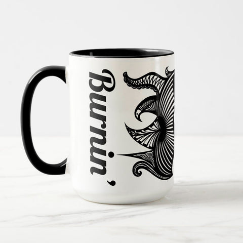 White ceramic coffee mug with a black handle and black interior, featuring a wrap‑around print of the artwork titled “Burnin’ Urchin.“