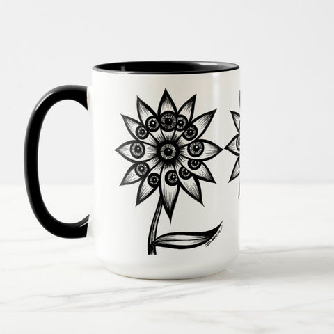 White ceramic coffee mug with a black handle and black interior, featuring a wrap‑around print of the artwork titled “Flowerize.“