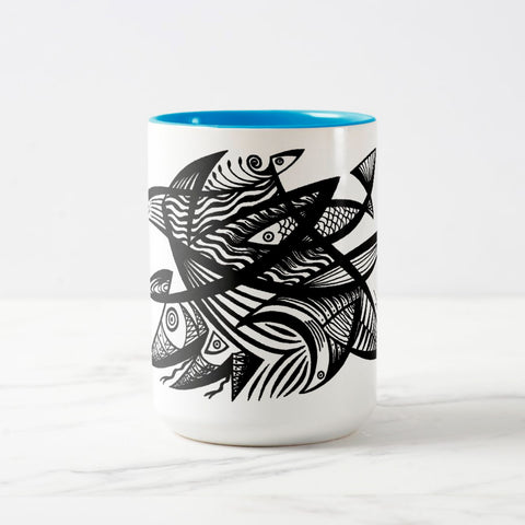 White ceramic coffee mug with a white handle and blue interior, featuring a wrap‑around print of the artwork titled “Pescados.“
