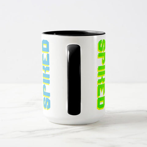 White ceramic coffee mug with a black handle and black interior, featuring a wrap‑around print of the artwork titled “Spiked.“