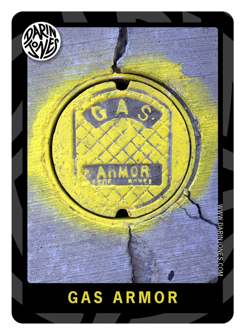 A photograph of a distressed, round, metal plate with bright yellow spray-paint highlights, concrete cracks with the text 'GAS ARMOR' across the plate and titled the same at the bottom, and a black and gray design border, the DARIN JONES logo in the upper left, and website on the right.