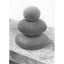 A black and white graphite drawing of three stacked rounded stones, as a cairn, on a wood surface, with a visible artist signature ‘Darin’ near the bottom right, with a wide white border.