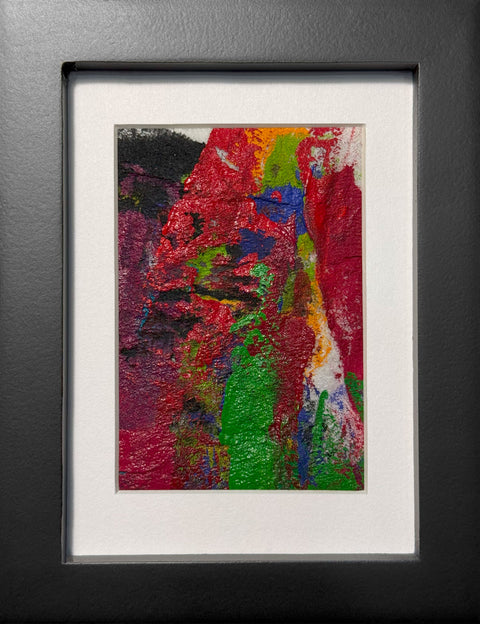 Abstract textured painting with layered brush and palette-knife strokes in bold red, green, yellow, purple, and black; matted in white and framed in black.