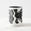 White ceramic coffee mug with a black handle and black interior, featuring a wrap‑around print of the artwork titled “Burnin’ Urchin.“