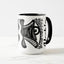 White ceramic coffee mug with a black handle and black interior, featuring a wrap‑around print of the artwork titled “Burnin’ Urchin.“