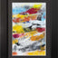 Abstract textured painting with layered brush and palette-knife strokes in red, yellow, blue, black, orange, and white on a white background; matted and framed in black.