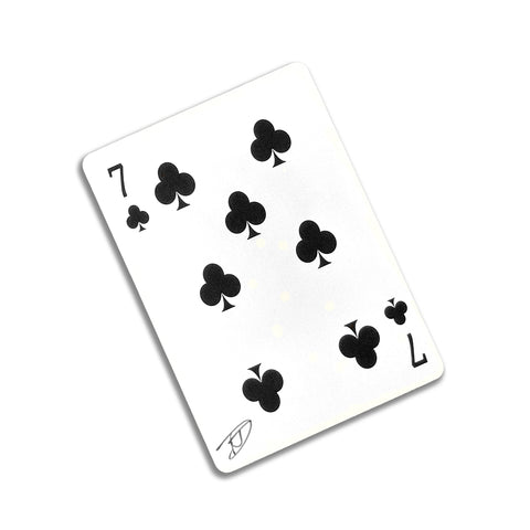 Back of the playing card showing the 7 of clubs with a hand‑signed signature ‘DJ’ in black ink.