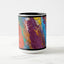 White ceramic coffee mug with a black handle and black interior, featuring a wrap‑around print of the artwork titled “Creative Palette.“