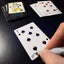 Back of the playing card showing the 7 of spades with a hand‑signed signature ‘DJ’ in black ink.