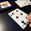 Back of the playing card showing the 6 of clubs with a hand‑signed signature ‘DJ’ in black ink.