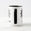White ceramic coffee mug with a black handle and black interior, featuring a wrap‑around print of the artwork titled “Flowerize.“