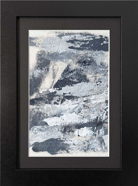 Abstract textured painting with layered brush and palette-knife strokes in shades of gray and white on a white background; matted and framed in black.