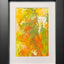 Abstract textured painting with layered brush and palette-knife strokes in orange, yellow, and green; matted in white and framed in black.