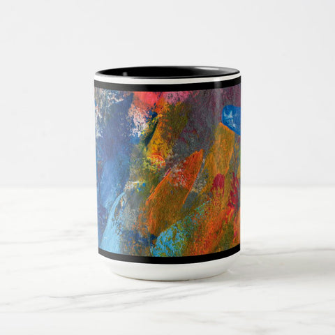 White ceramic coffee mug with a black handle and black interior, featuring a wrap‑around print of the artwork titled “Jubilation Palette.“