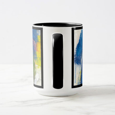 White ceramic coffee mug with a black handle and black interior, featuring a wrap‑around print of the artwork titled “Jubilation Palette.“