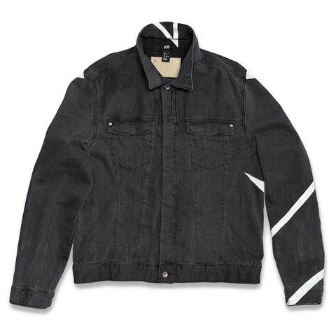 A black washed denim jacket with white pointed and diagonal stripe accents on the shoulders, sleeve, and collar, displayed flat against a white background.