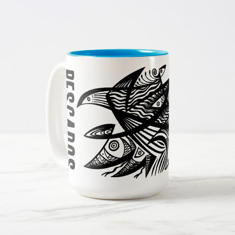 White ceramic coffee mug with a white handle and blue interior, featuring a wrap‑around print of the artwork titled “Pescados.“