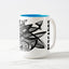 White ceramic coffee mug with a white handle and blue interior, featuring a wrap‑around print of the artwork titled “Pescados.“