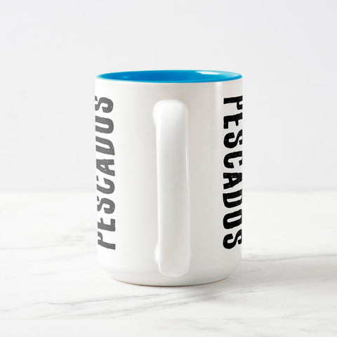White ceramic coffee mug with a white handle and blue interior, featuring a wrap‑around print of the artwork titled “Pescados.“