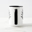 White ceramic coffee mug with a black handle and black interior, featuring a mirrored black and white print of the artwork titled “Pinned.“