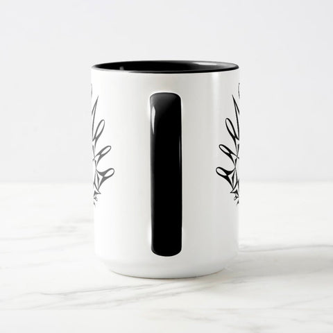 White ceramic coffee mug with a black handle and black interior, featuring a mirrored black and white print of the artwork titled “Pinned.“