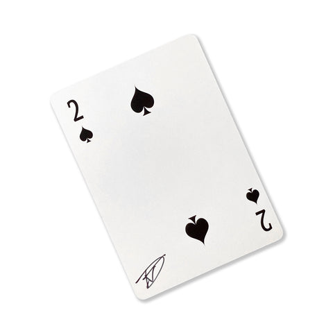 Back of the playing card showing the 2 of spades with a hand‑signed signature ‘DJ’ in black ink.