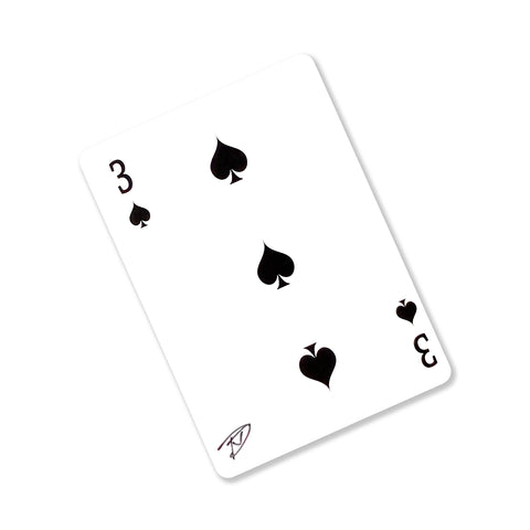 Back of the playing card showing the 3 of spades with a hand‑signed signature ‘DJ’ in black ink.