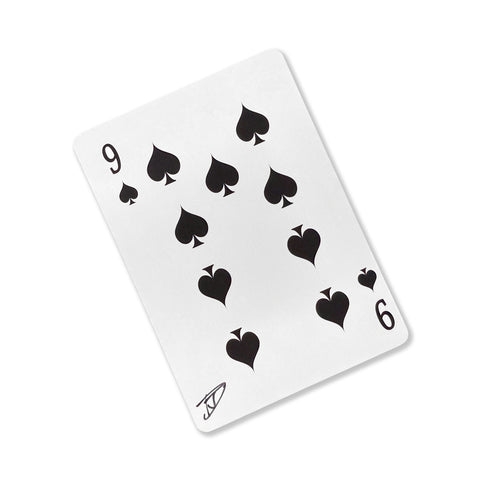 Back of the playing card showing the 9 of spades with a hand‑signed signature ‘DJ’ in black ink.