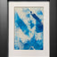 Abstract textured painting with layered brush and palette-knife strokes in blue; matted in white and framed in black.