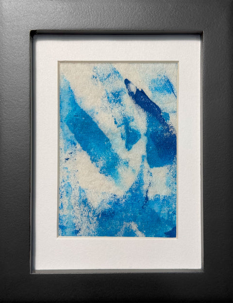 Abstract textured painting with layered brush and palette-knife strokes in blue; matted in white and framed in black.