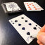 Back of the playing card showing the 8 of spades with a hand‑signed signature ‘DJ’ in black ink.