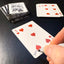 Back of the playing card showing the 5 of hearts with a hand‑signed signature ‘DJ’ in black ink.