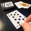 Back of the playing card showing the 10 of spades with a hand‑signed signature ‘DJ’ in black ink.