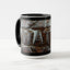 A white ceramic coffee mug with a black handle and black interior, featuring the ‘WAT’ section of a wrap-around photographic print of a wet street plate with the word ‘WATER’. 